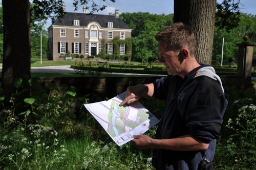 Man staat voor een monument en bekijkt een plattegrond